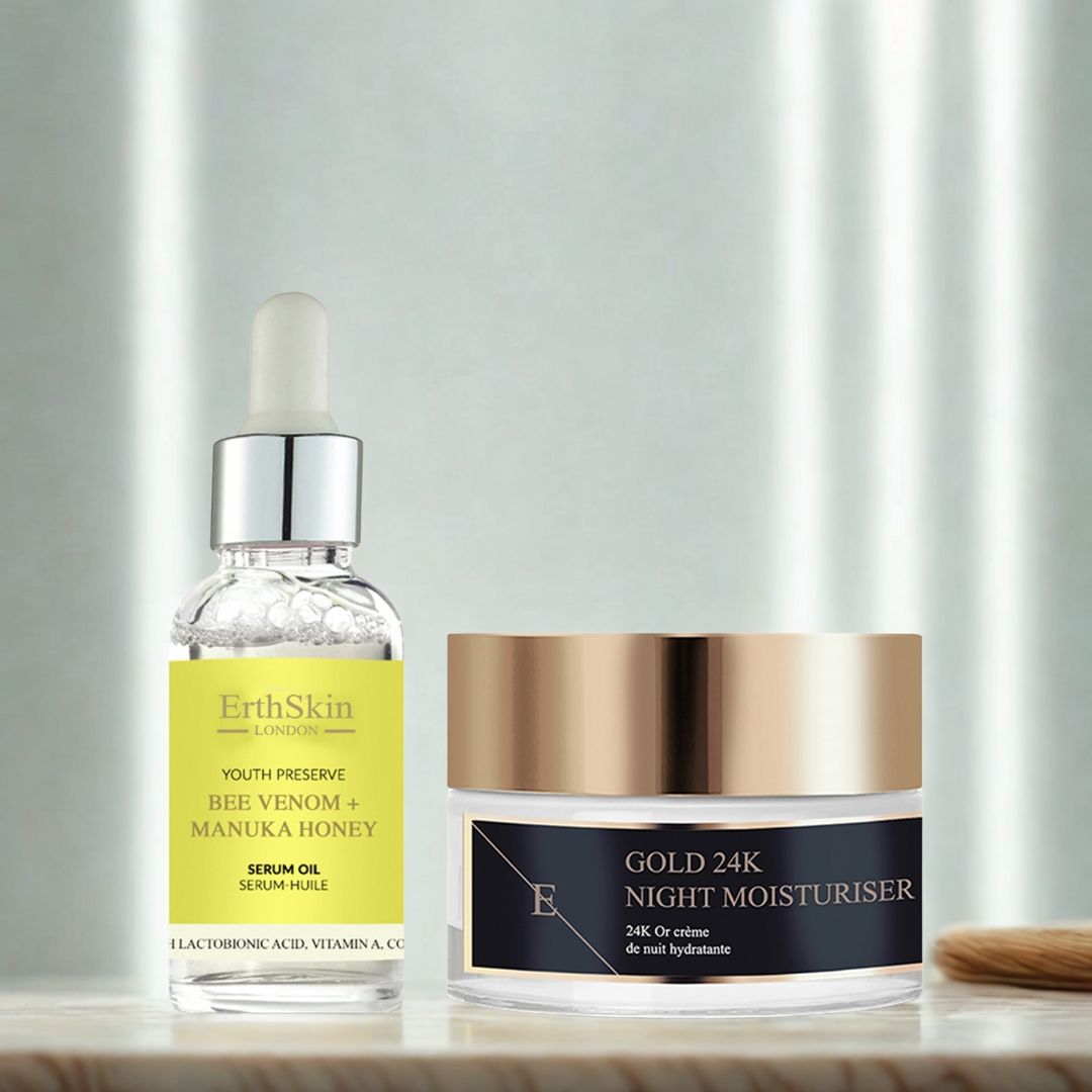 Serumflasche und Cremebehälter. Serum mit Pipette, gelbes Etikett. Cremebehälter mit goldfarbenem Deckel. Beschriftung: Gold 24K Night Moisturiser. Pinsel.