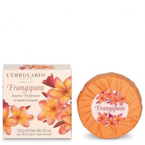 Seife und Verpackung. Aufschrift: Frangipani, L'Erbolario. Runde Seife in orangefarbenem Papier verpackt. Auf der Verpackung Blüten.