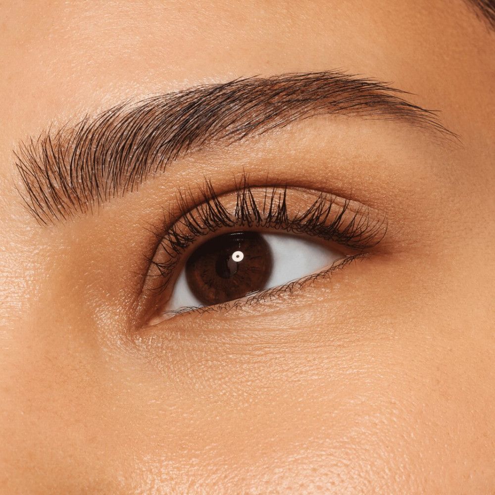 Nahaufnahme eines Auges mit geformten Augenbrauen. Die Augenbraue ist dunkelbraun und gut definiert.