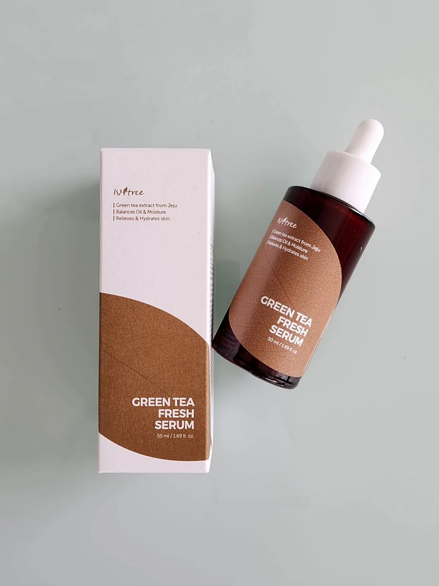 Produktverpackung und Flasche. Weiße Schachtel und braune Glasflasche mit Pipette. ISNTREE Green Tea Fresh Serum.
