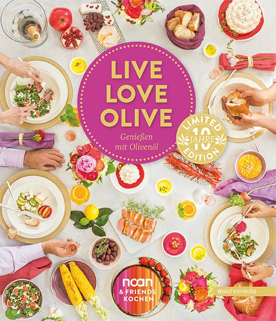 Tisch mit Speisen und dem Schriftzug "LIVE LOVE OLIVE". Limitiert 10 Jahre Edition. Verschiedene Gerichte, Hände beim Essen.