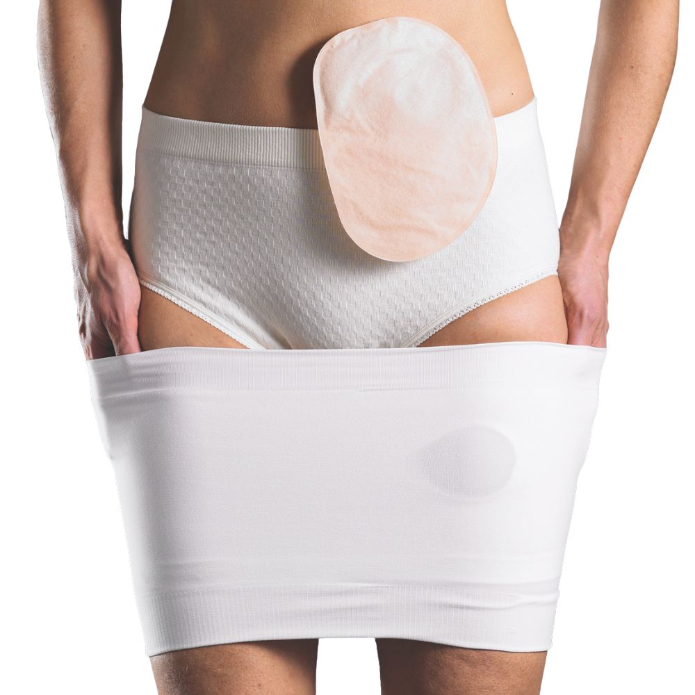 Person trägt weiße Unterwäsche und einen weißen Bauchgurt. Ein Stoma-Beutel ist sichtbar.