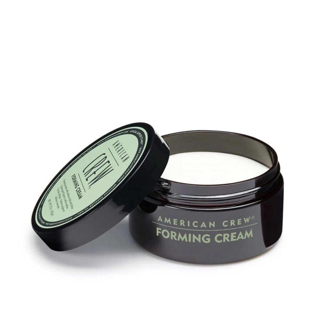 Geöffneter, dunkelbrauner Tiegel mit Deckel daneben. Aufschrift: American Crew Forming Cream. Cremefarbener Inhalt sichtbar.