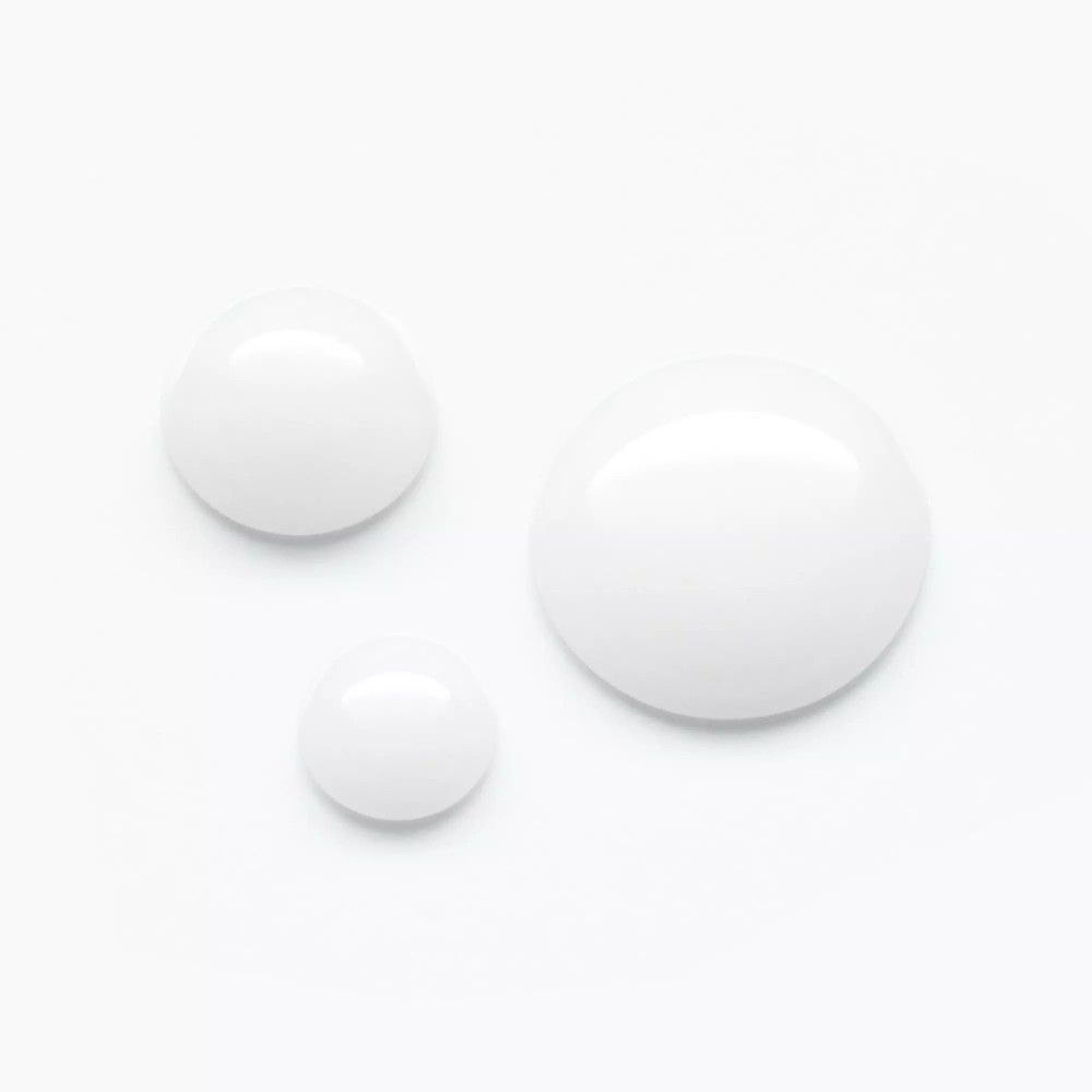 Drei weiße Serumtropfen auf weißem Hintergrund. Unterschiedliche Größen.