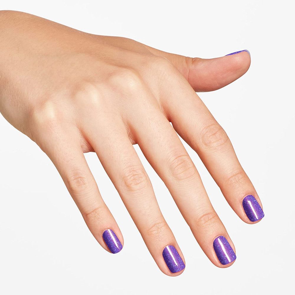 Hand mit lackierten Nägeln in Lila mit Glitzer.