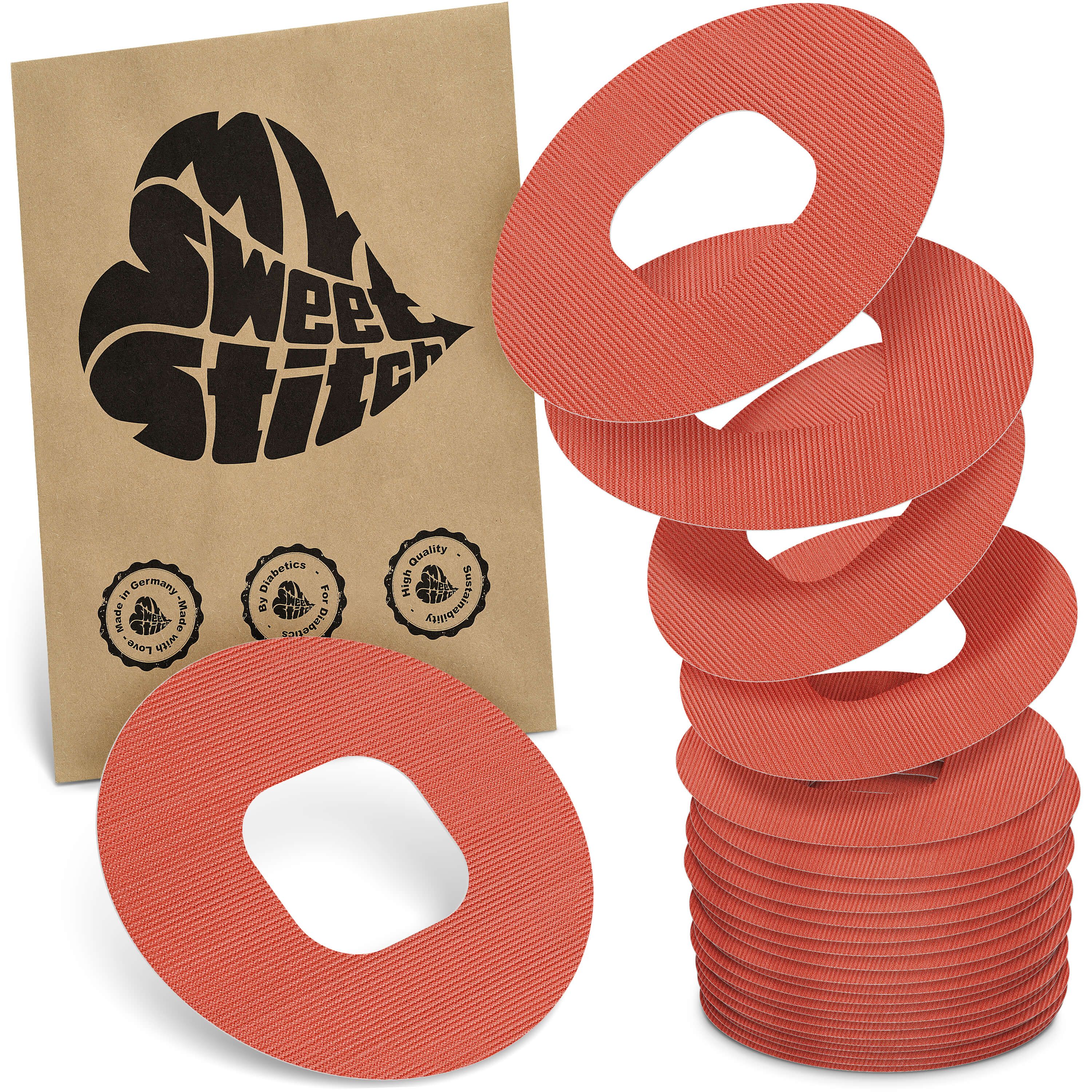 Runde, orangefarbene Pflaster mit Loch in der Mitte. Auf brauner Verpackung steht "My Sweet Stitch".