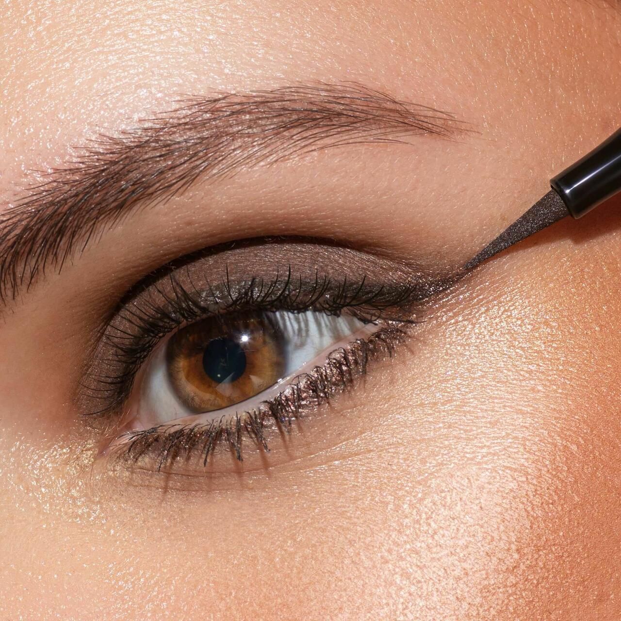 Auge mit braunem Lidstrich, aufgetragen mit Artdeco Sensitive Fine Liner. Braune Augen, Hautton. Produktanwendung.