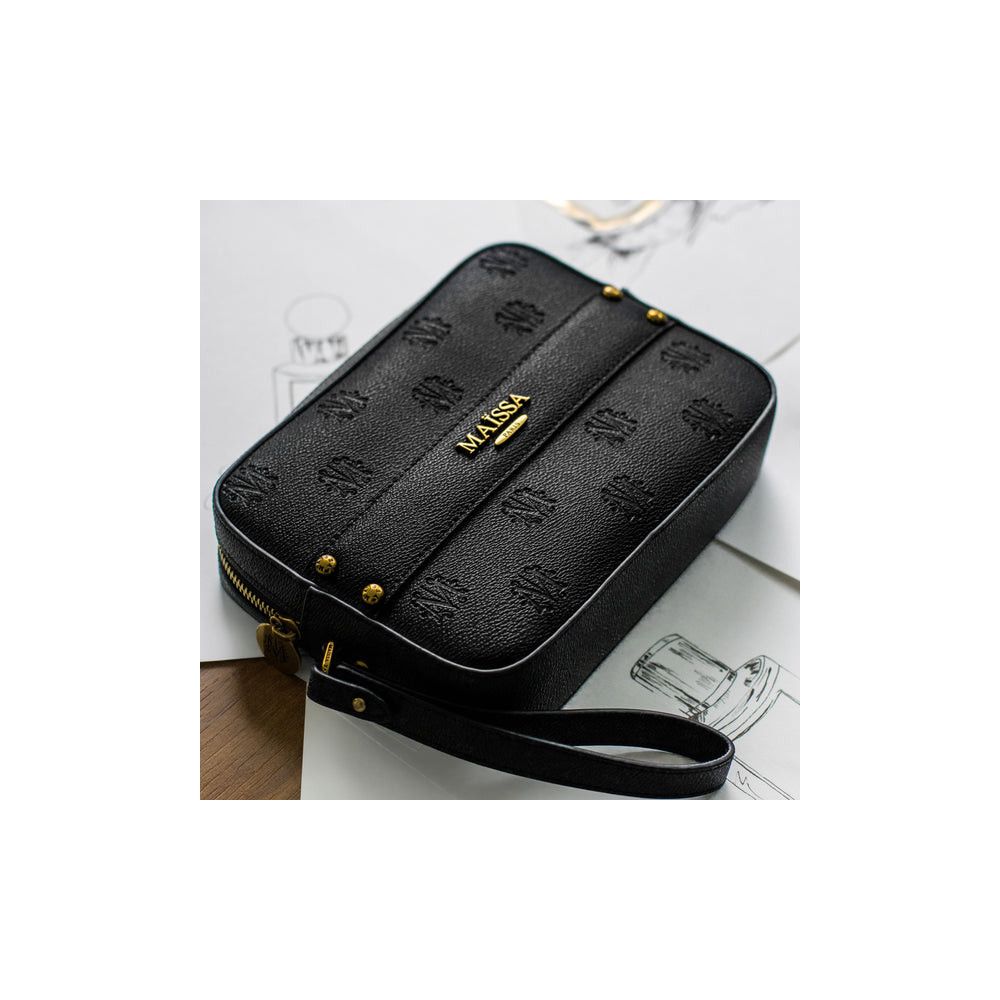 Schwarze Tasche mit goldfarbenem MAISSA-Schriftzug und Logo. Goldfarbene Nieten und Reißverschluss.
