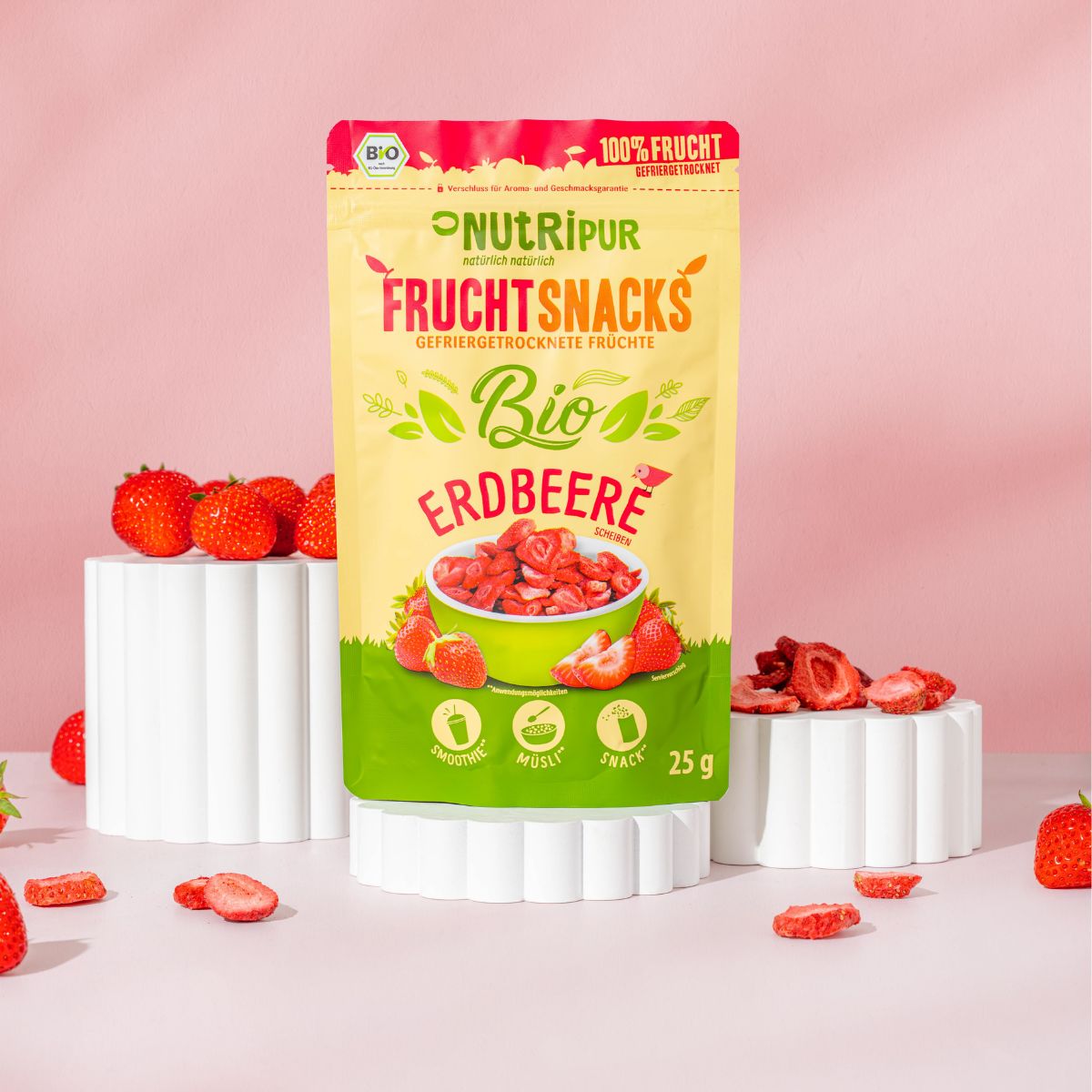Packung gefriergetrocknete Erdbeeren auf Podest. Aufschrift: NutriPur, Bio Erdbeere, Fruchtsnacks. 25g. Bio-Siegel.