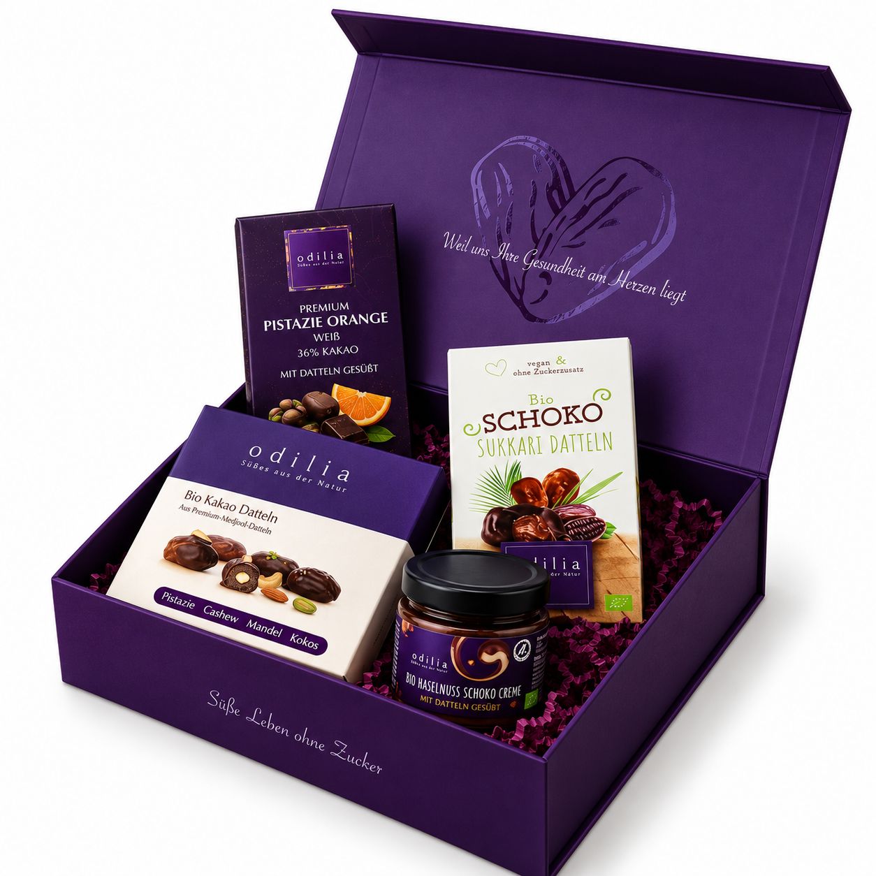 Lila Geschenkbox mit Odilia Produkten: Bio Schoko Sukkari Datteln, Bio Kakao Datteln, Pistazie Orange weiße Schokolade, Dattel-Mandel-Creme.