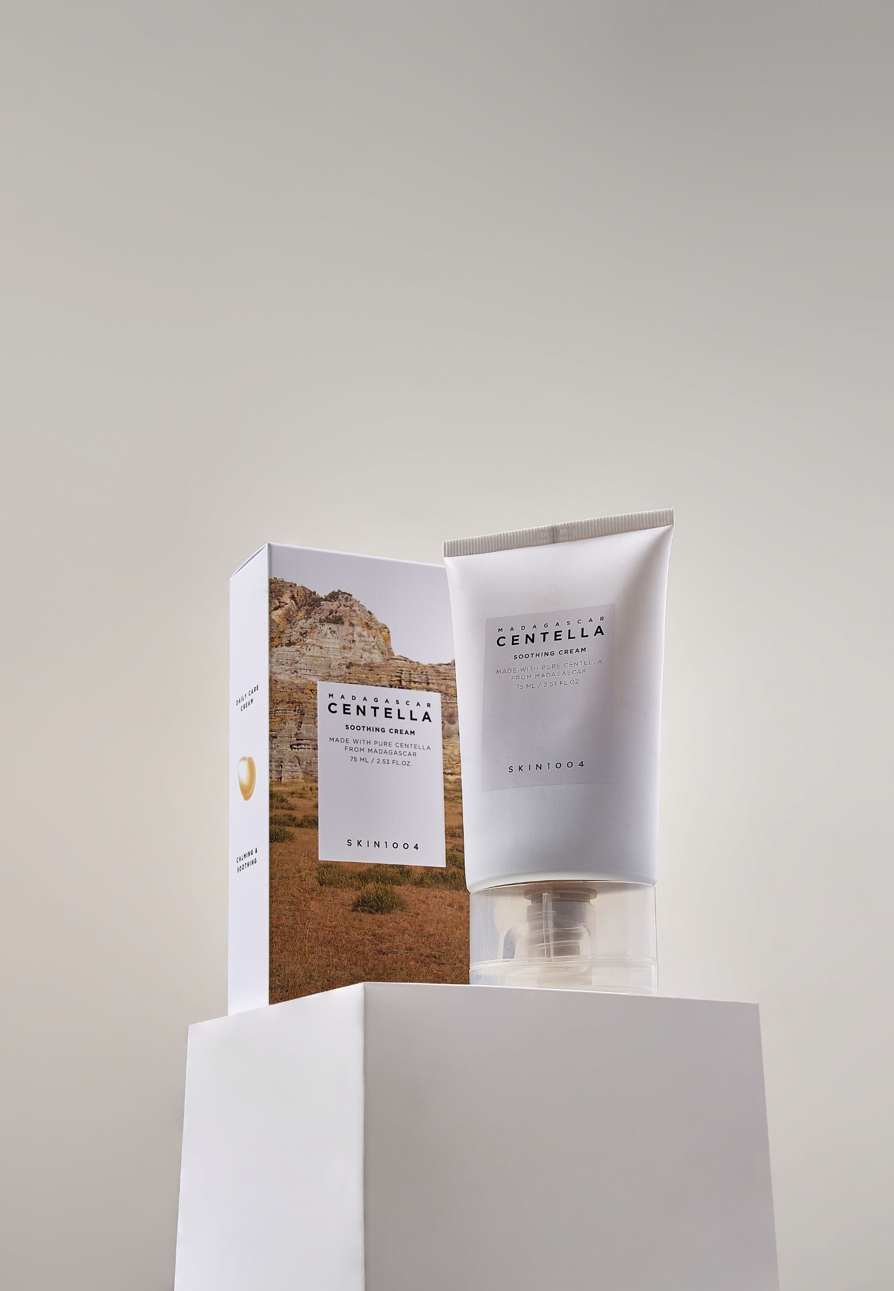 SKIN1004 Madagascar Centella Soothing Cream und Verpackung auf weißem Podest. Tube und Karton nebeneinander.