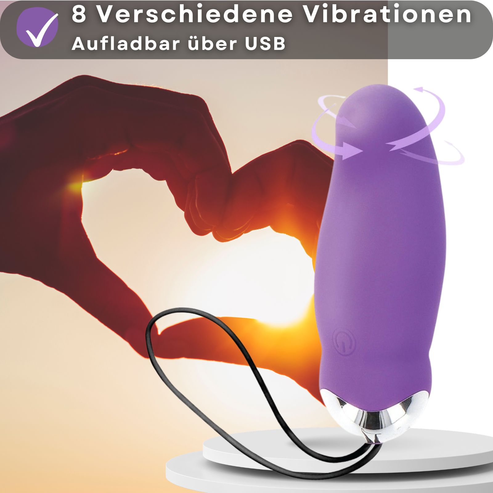 Lila Vibrator. Wiederaufladbar über USB. 8 Vibrationsmodi. Produkt auf Podest. Hände im Hintergrund.