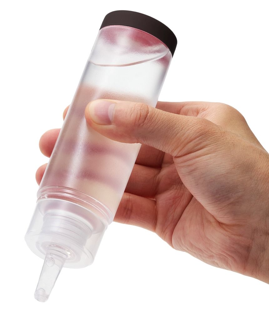 Durchsichtige Flasche mit schwarzem Deckel, gehalten von einer Hand. Enthält klare Flüssigkeit.