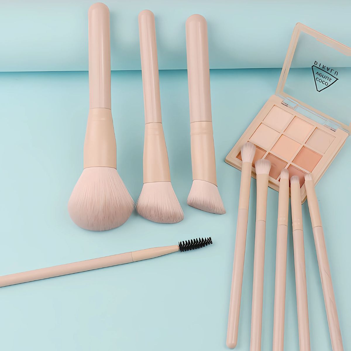 Ein Set von vier hellbeigen Make-up-Pinsel und eine Lidschattenpalette mit acht Farben.
