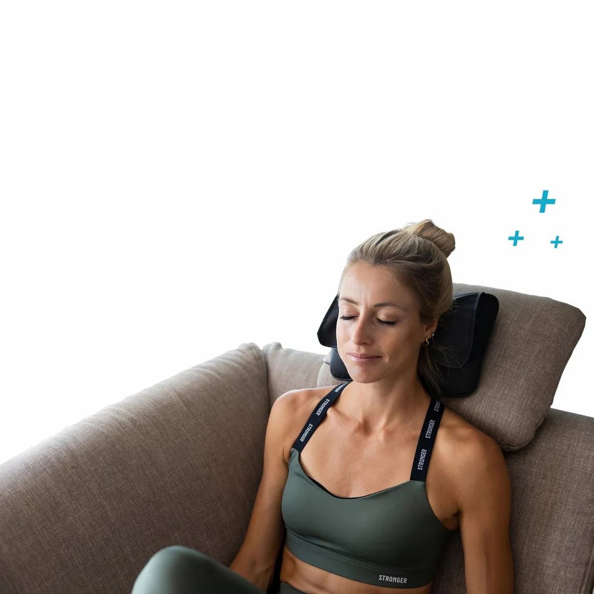 Frau auf Sofa mit Nackenmassagekissen. Schwarzes Kissen am Nacken. Frau mit geschlossenen Augen.