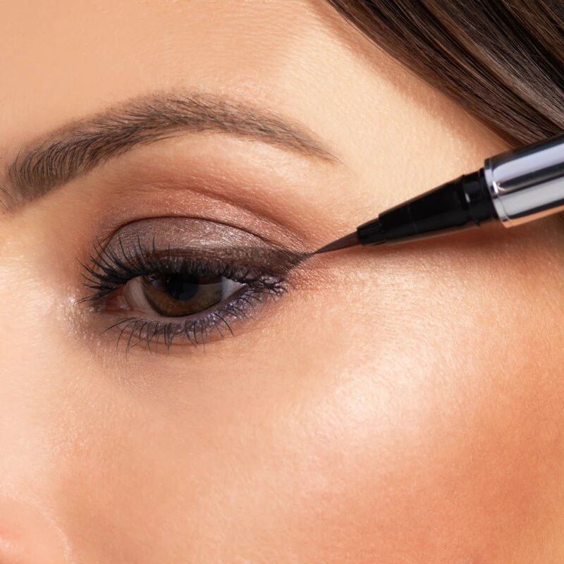 Nahaufnahme eines Auges, auf das mit einem flüssigen Eyeliner aufgetragen wird.