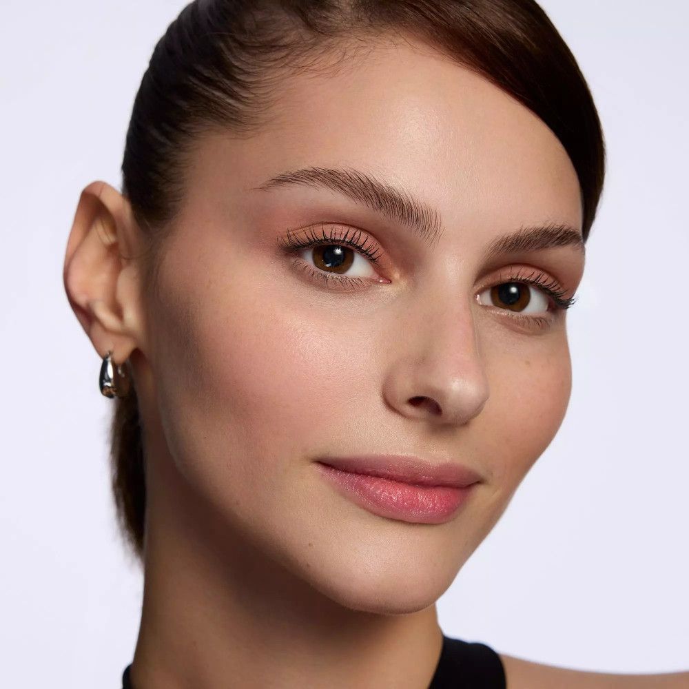 Porträt einer Frau mit dunklen Augen und dunklen Haaren. Sie trägt Ohrringe.