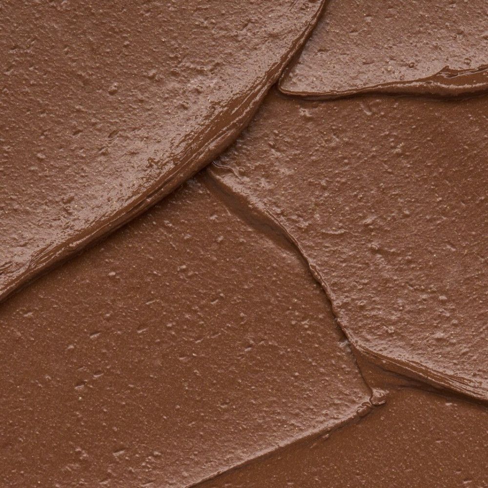 Nahaufnahme von brauner, cremiger Substanz. Die Textur ist uneben und schimmernd.