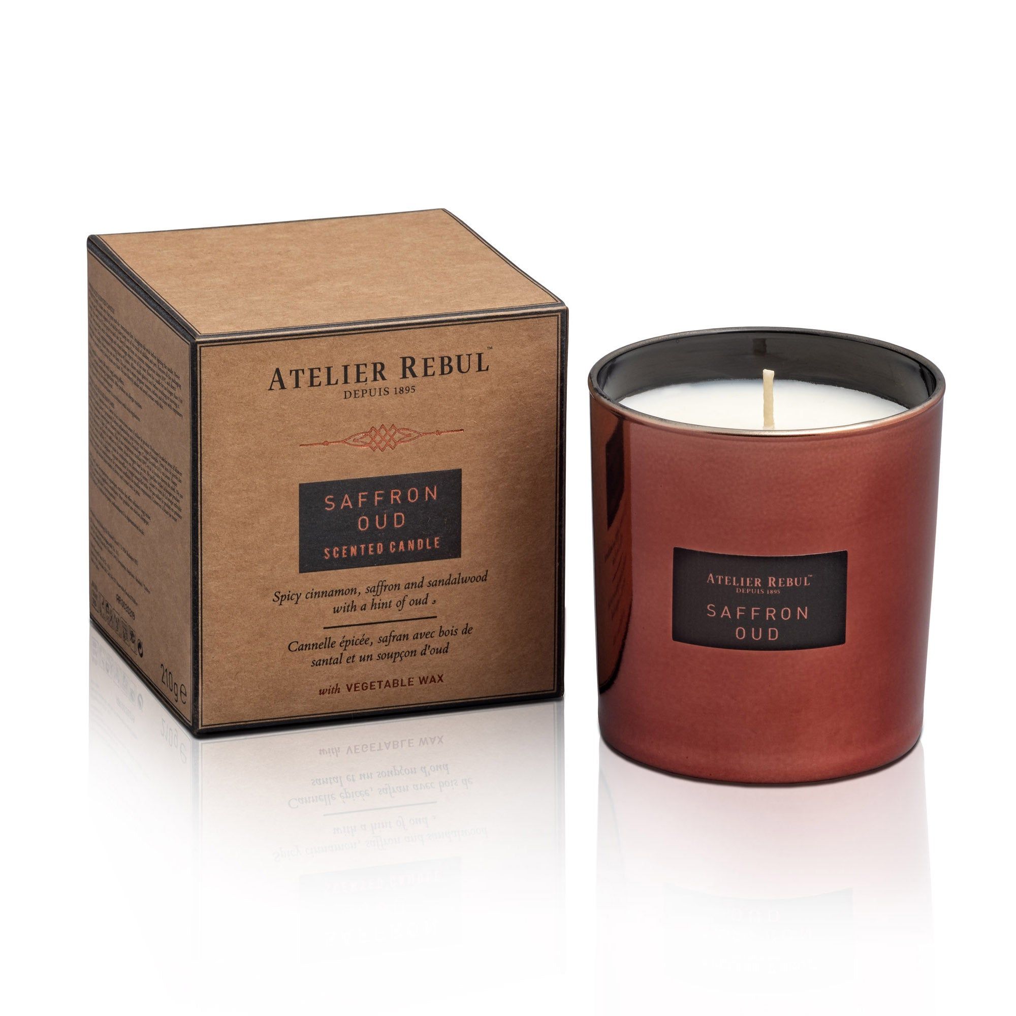 Duftkerze in roter Glasverpackung neben einer braunen Schachtel. Aufschrift: Atelier Rebul, Saffron Oud, Scented Candle.