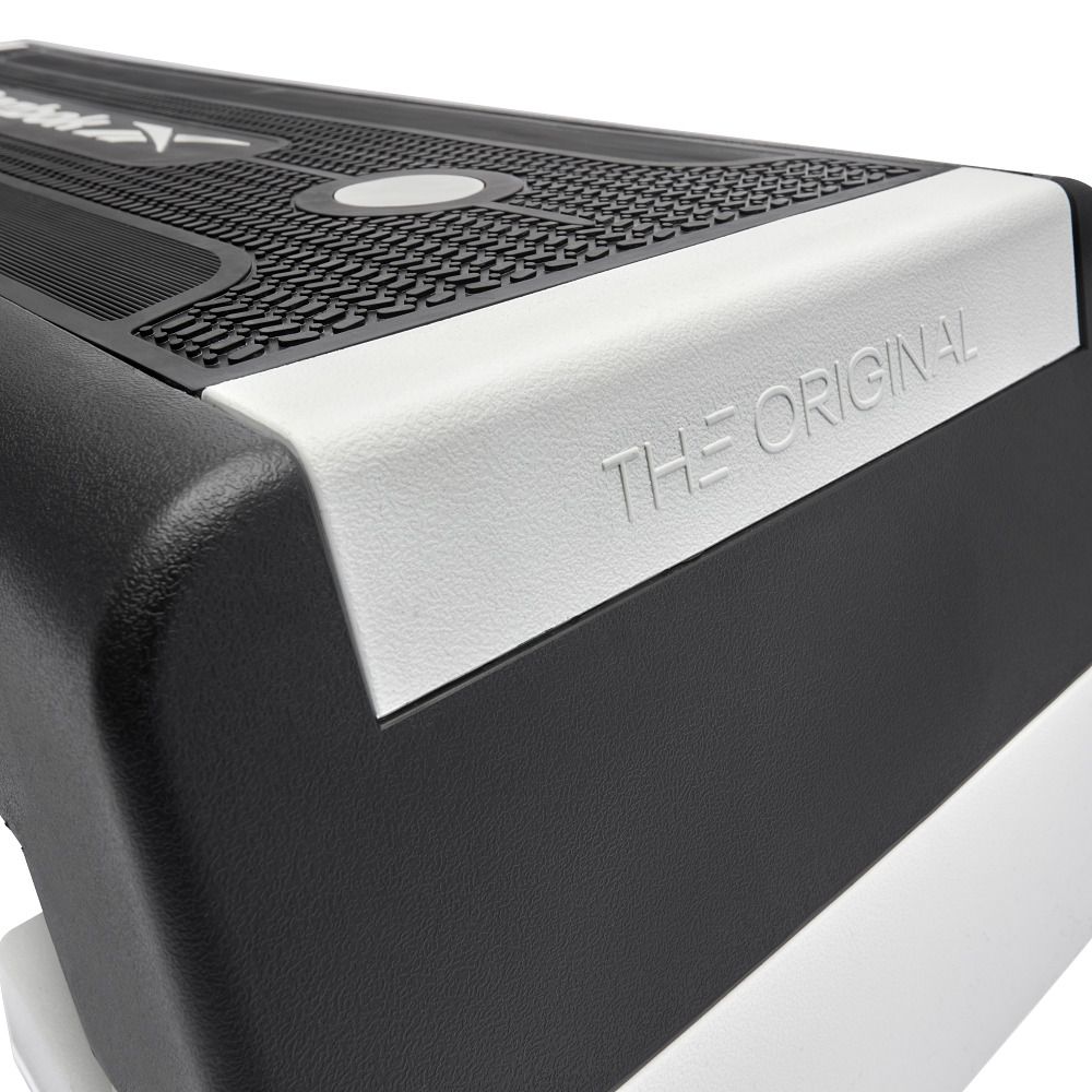 Nahaufnahme eines Reebok Steps. Schwarze Oberfläche mit weißem Schriftzug 'THE ORIGINAL'.