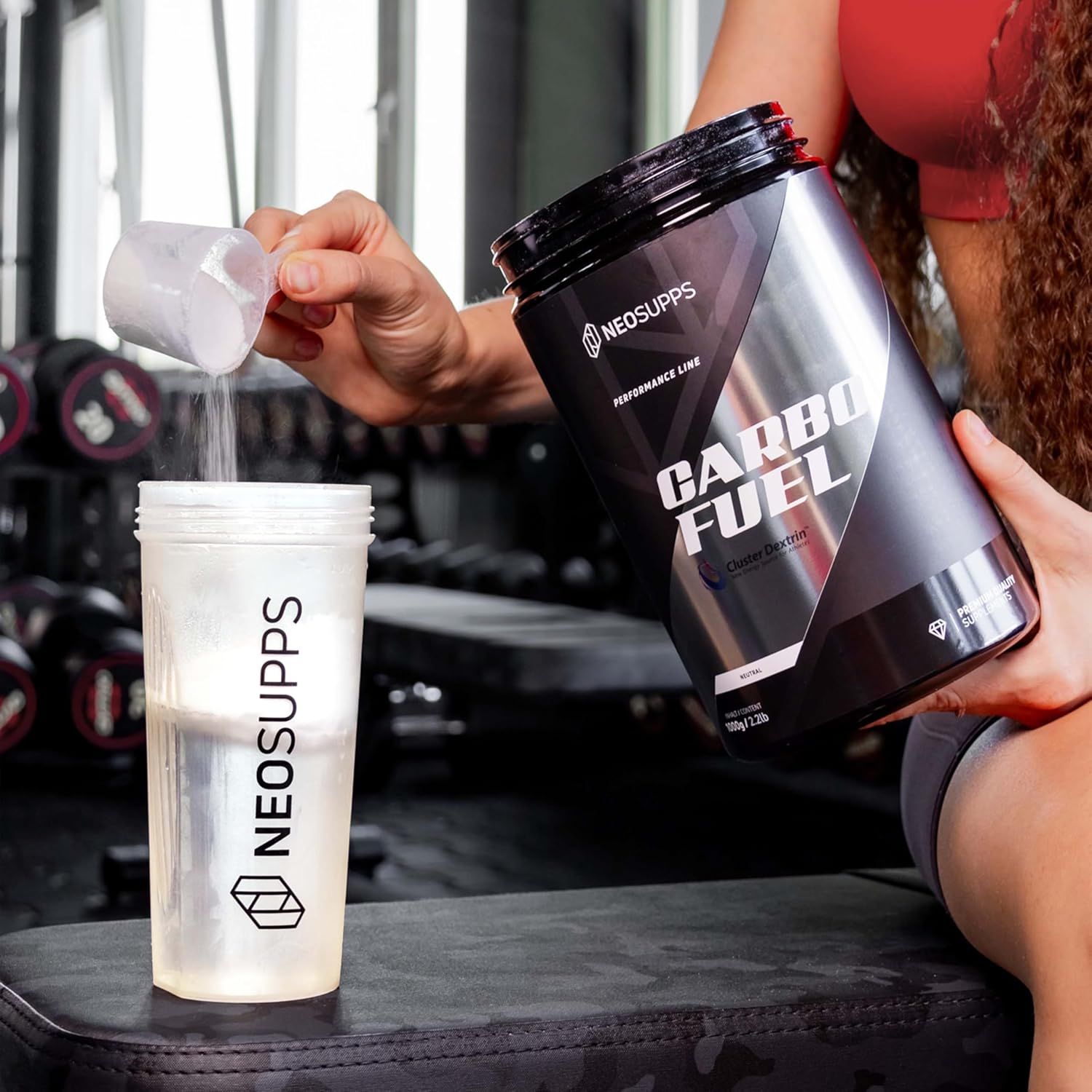 Person gießt Pulver aus Dose in Shaker. Auf dem Shaker steht "NEOSUPPS". Dose: "CARBO FUEL".