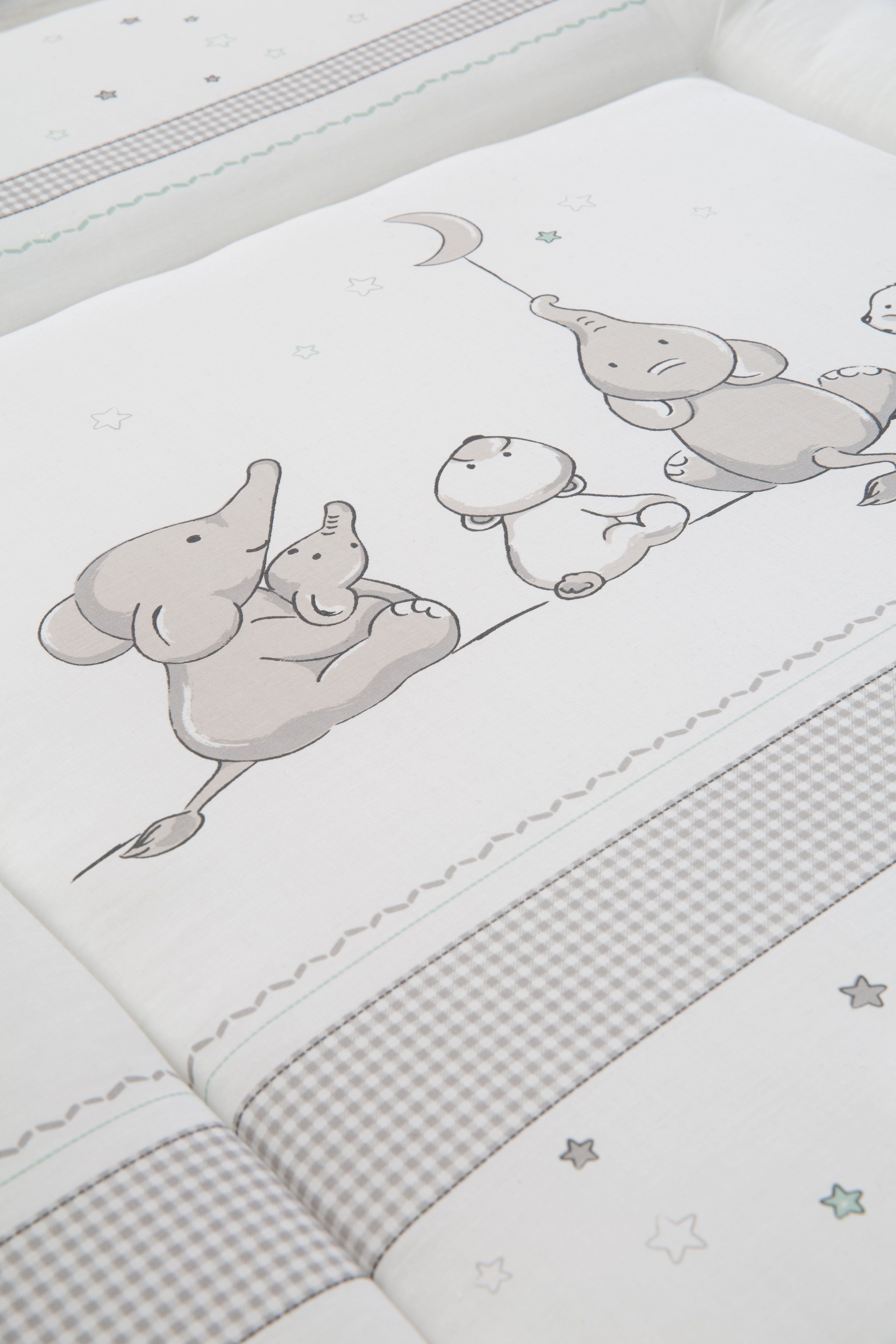 Detail Wickelauflage mit Tiermotiven. Weiße Oberfläche mit Elefanten-Illustrationen. Graue und grüne Akzente. Sternenmuster.