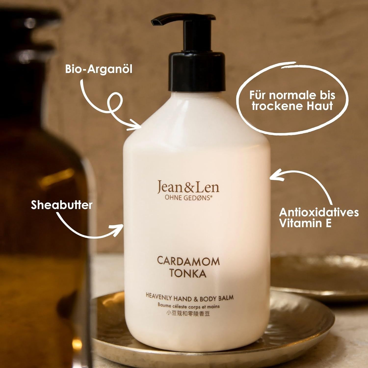 Weiße Flasche mit schwarzem Pumpaufsatz. Aufschrift: Cardamom Tonka. Heavenly Hand & Body Balm. Bio-Arganöl, Sheabutter.