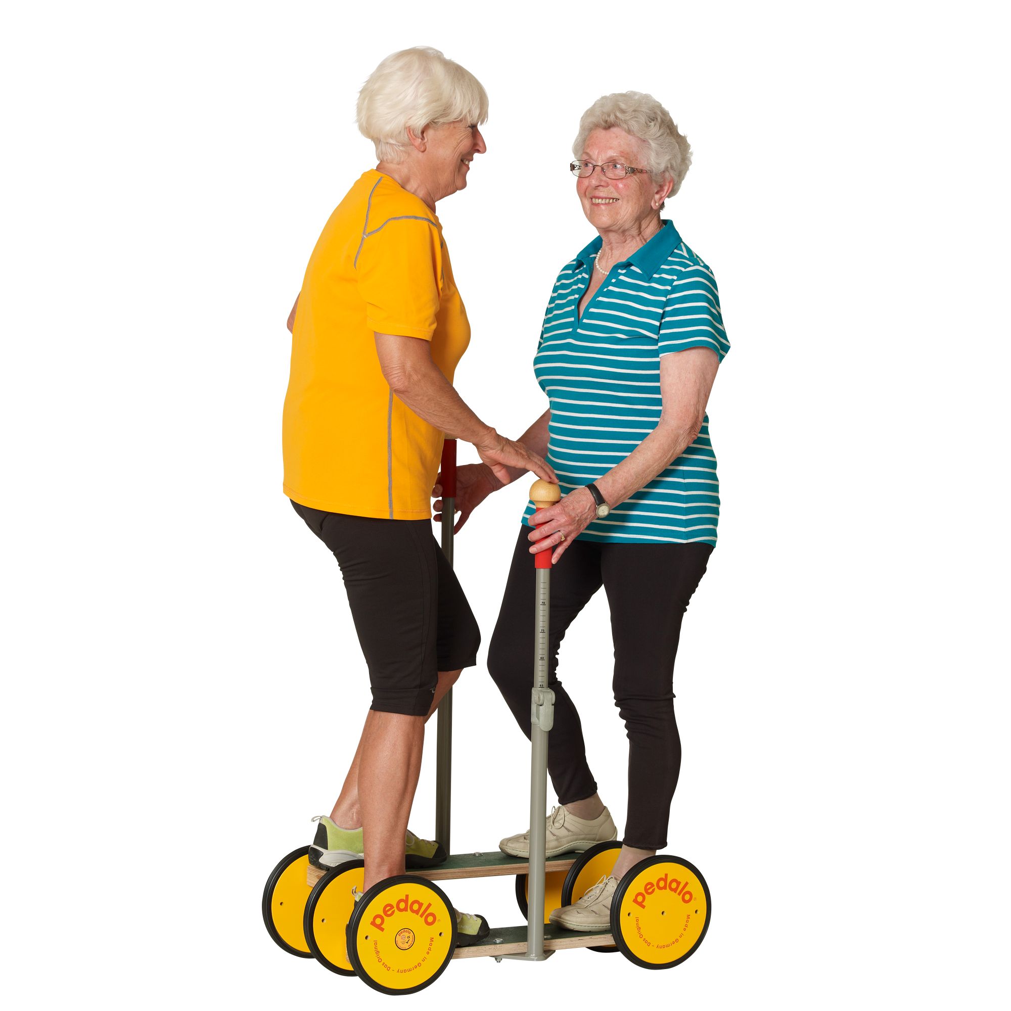 Zwei Frauen auf einem Pedalo® Combi. Eine Frau steht auf dem Gerät, die andere hält sie fest. Gelbe Räder, schwarze Trittflächen, Haltestange.