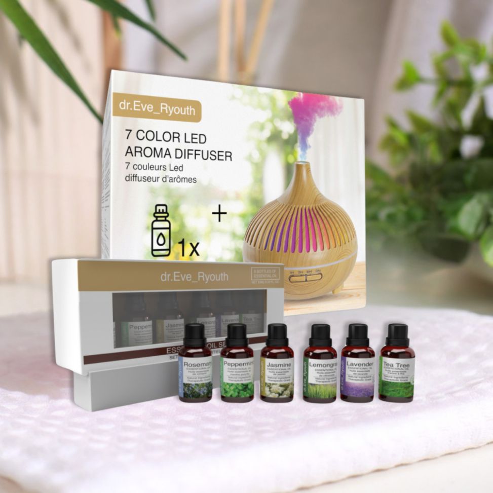 Dr. Eve Ryouth 7-Farben LED Aroma Diffusor und 6 ätherische Öle. Diffusor mit Holzmaserung, farbiger Nebel, 6 Ölflaschen auf weißem Tuch.