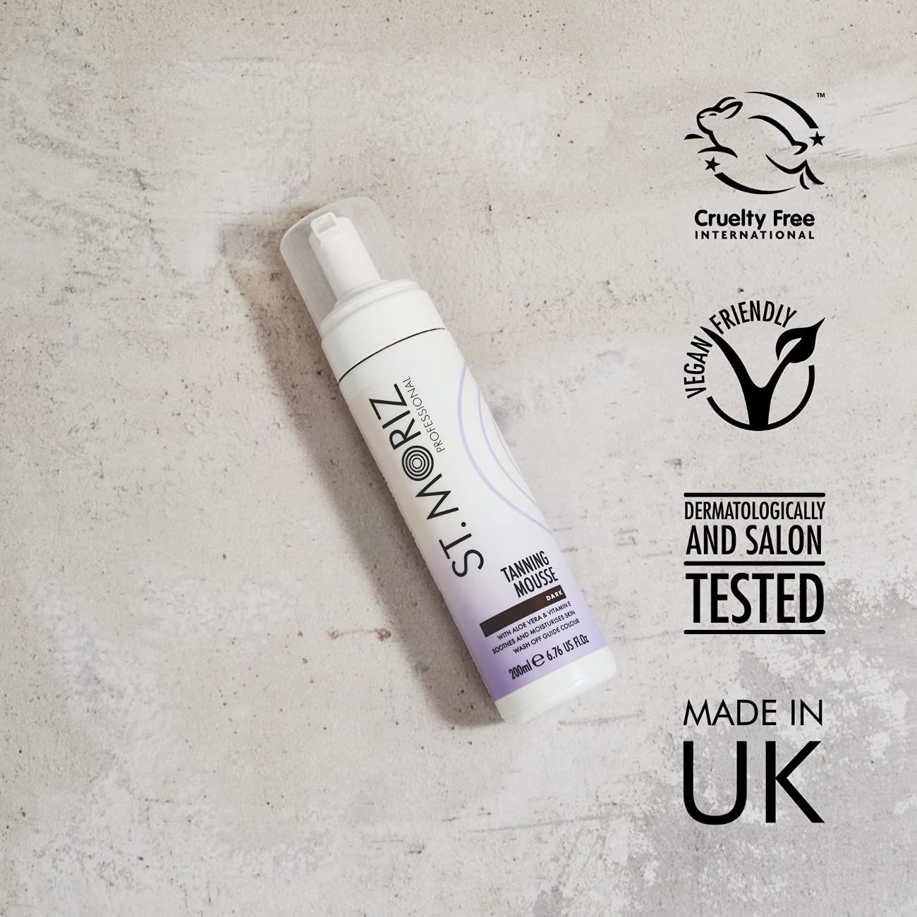 St. Moriz Selbstbräuner Mousse, dunkel. Weiße Flasche mit Sprühkopf, lila Etikett, Text. Vegan, Cruelty Free, Made in UK.