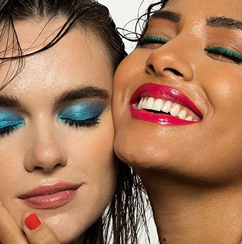 Zwei Frauen mit Make-up. Eine Frau mit blauem Lidschatten, die andere mit rotem Lippenstift. Beide lächeln.