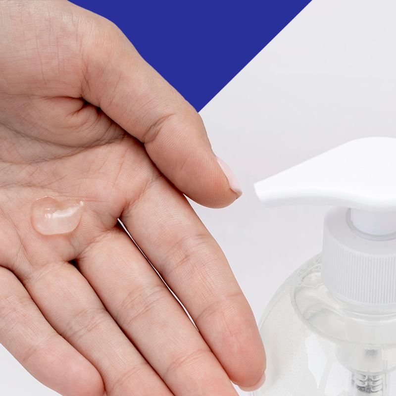 Nahaufnahme einer Hand mit einem Tropfen transparentem Gel. Daneben ein weißer Pumpkopf.