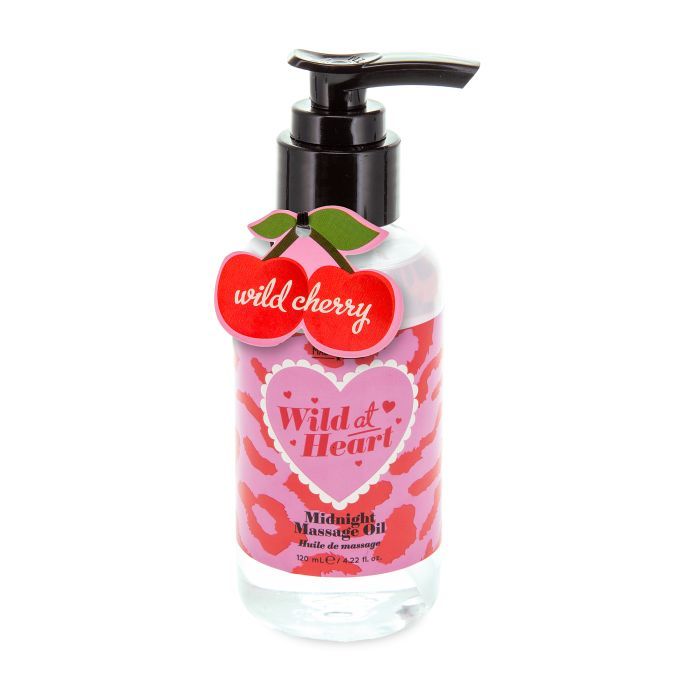 Massageöl-Flasche mit schwarzem Pumpkopf. Kirsch-Anhänger mit Schriftzug "Wild Cherry". Rosa Etikett mit "Wild at Heart" und "Midnight Massage Oil".