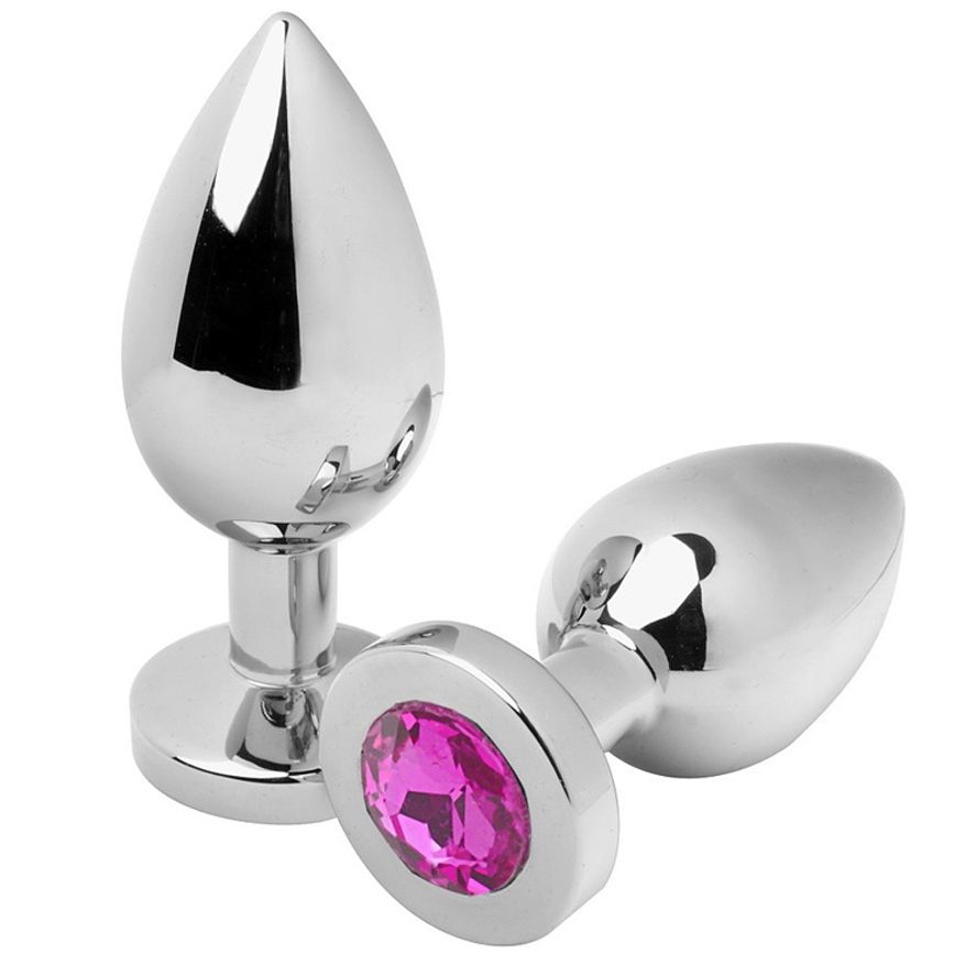 Zwei metallische Analplugs. Einer mit rosa Schmuckstein. Tropfenförmige Spitze, runder Sockel.