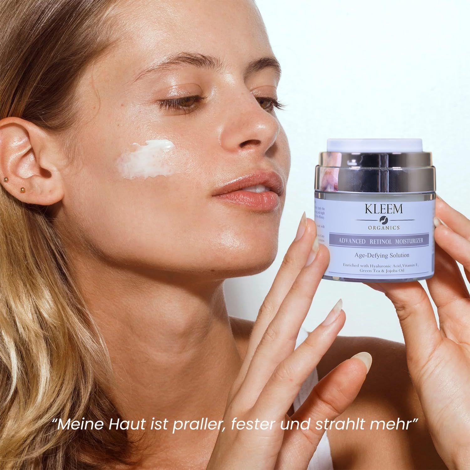 Frau hält Cremebehälter. Text: Kleem Organics, Advanced Retinol Moisturizer, Age-Defying Solution. Zitat: Meine Haut ist praller, fester und strahlt mehr.