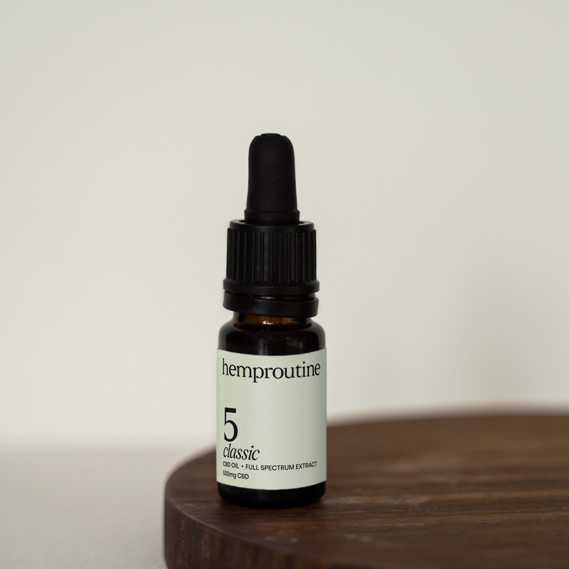 Braune Glasflasche mit schwarzem Tropfer. Aufkleber mit "hemproutine 5 classic".