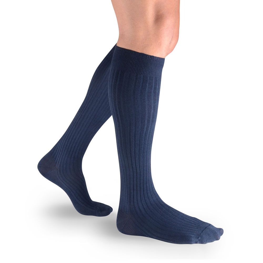 Marineblaue Kompressionsstrümpfe für Männer. Geripptes Design, bis zum Knie reichend. Auf weißem Hintergrund, Beinansicht.