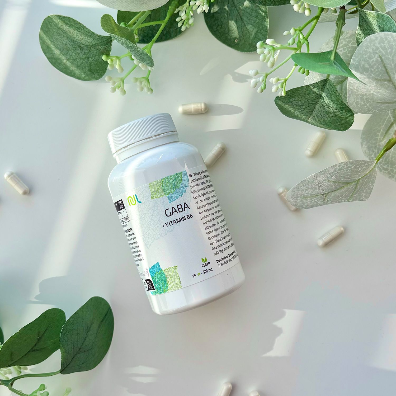 Weiße Flasche mit Kapseln. Aufschrift: Gaba + Vitamin B6. Vegan-Siegel. Kapseln liegen verstreut.