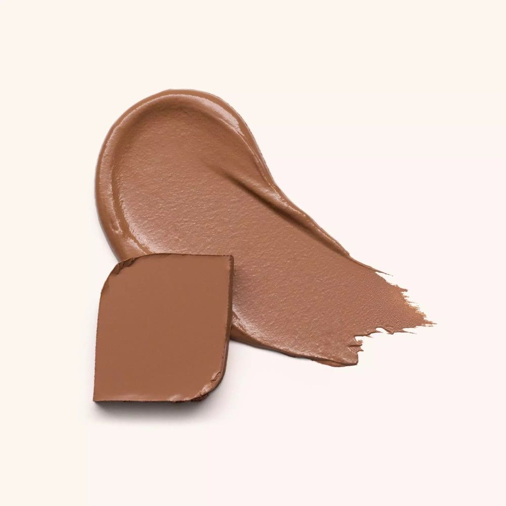 Braune Creme und fester Bronzer nebeneinander. Creme-Textur in einem Strich, fester Bronzer in quadratischer Form.