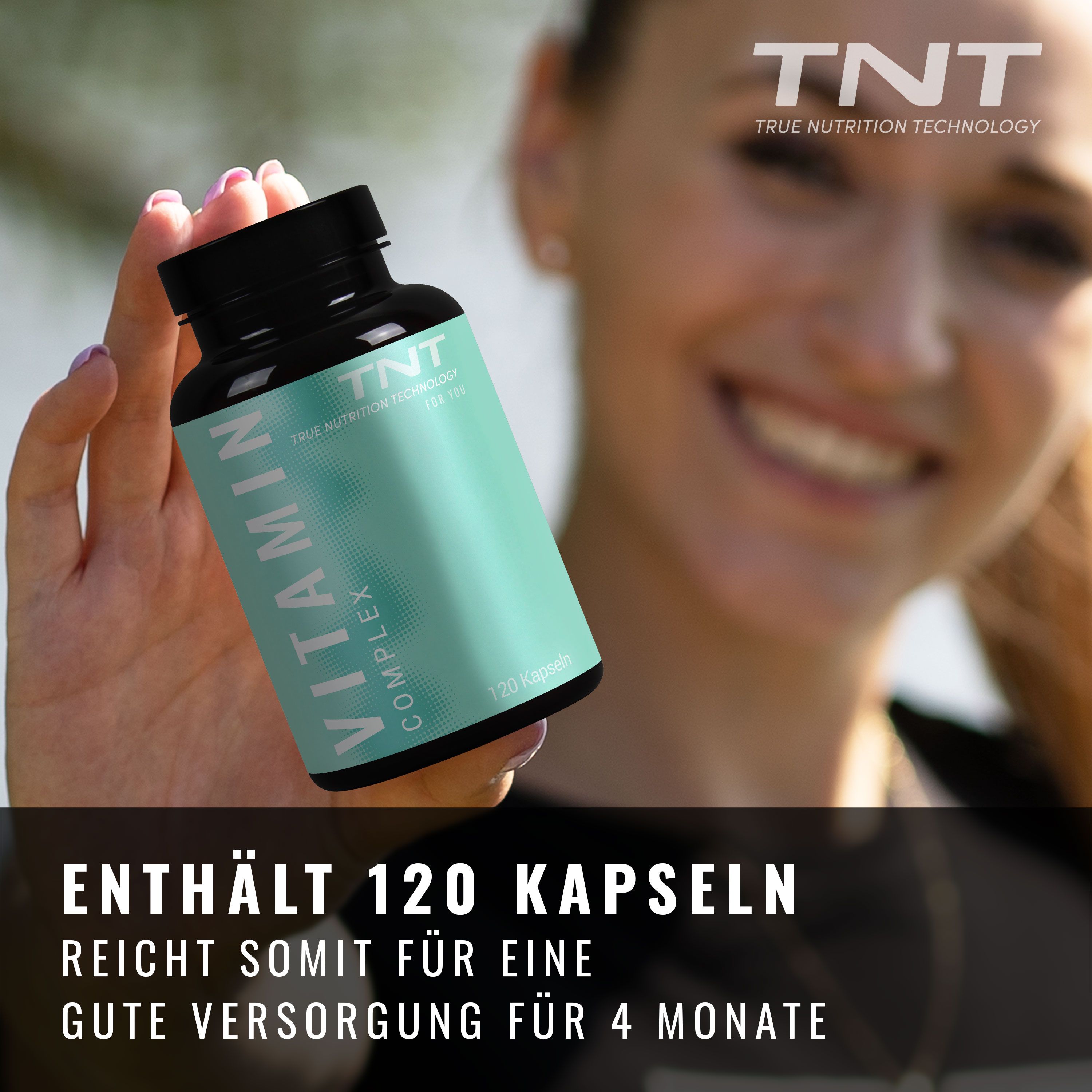 Grüne Flasche mit schwarzem Deckel. Aufschrift: Vitamin Complex. Enthält 120 Kapseln. Frau hält die Flasche.