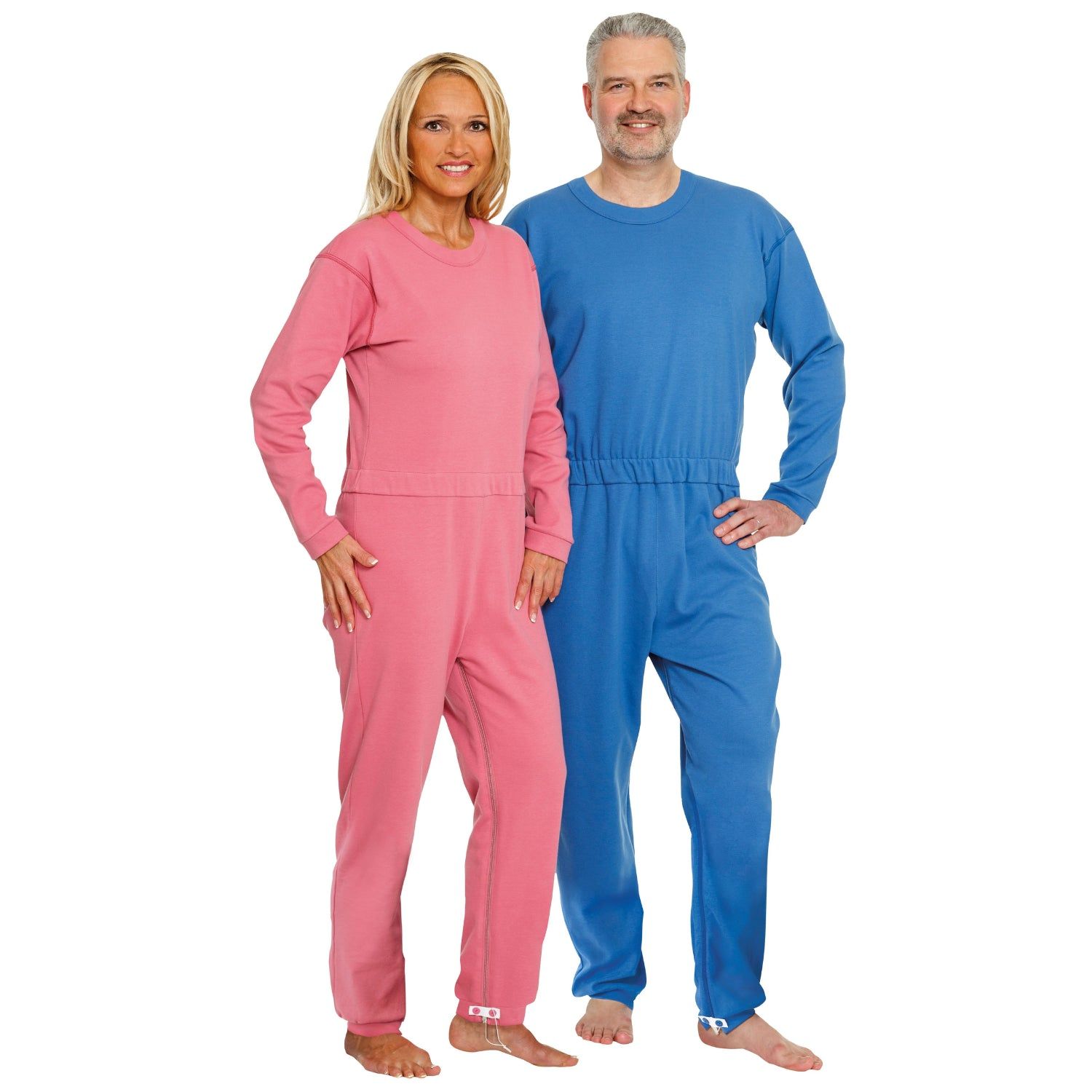 Zwei Personen tragen Pflegeoveralls. Eine Person trägt einen rosa Overall, die andere einen blauen Overall.