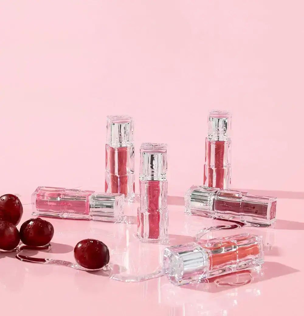 Applikatoren von TINTIR Waterism Glow Tints in einer Glaskugel, umgeben von Fläschchen.