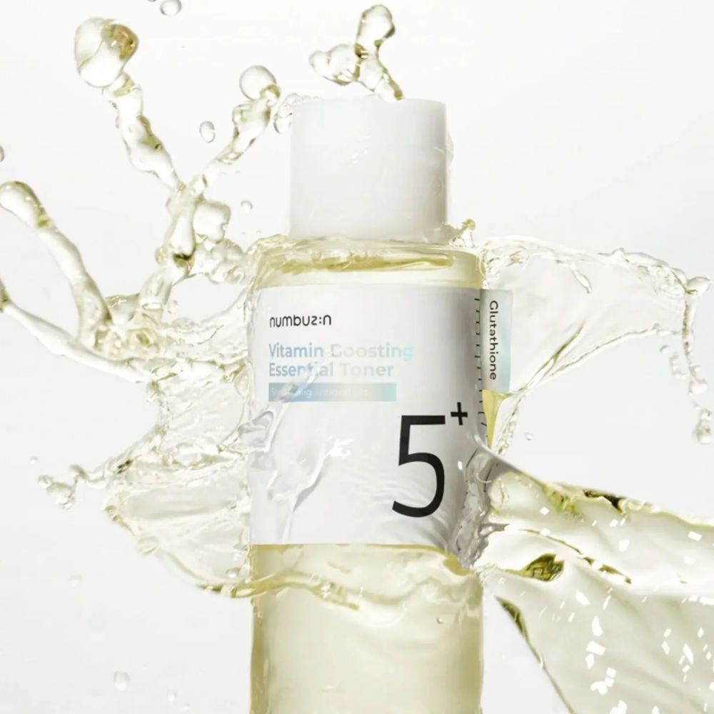 Numbuzin No.5 Vitamin Boosting Essential Toner umgeben von Wasserspritzern.