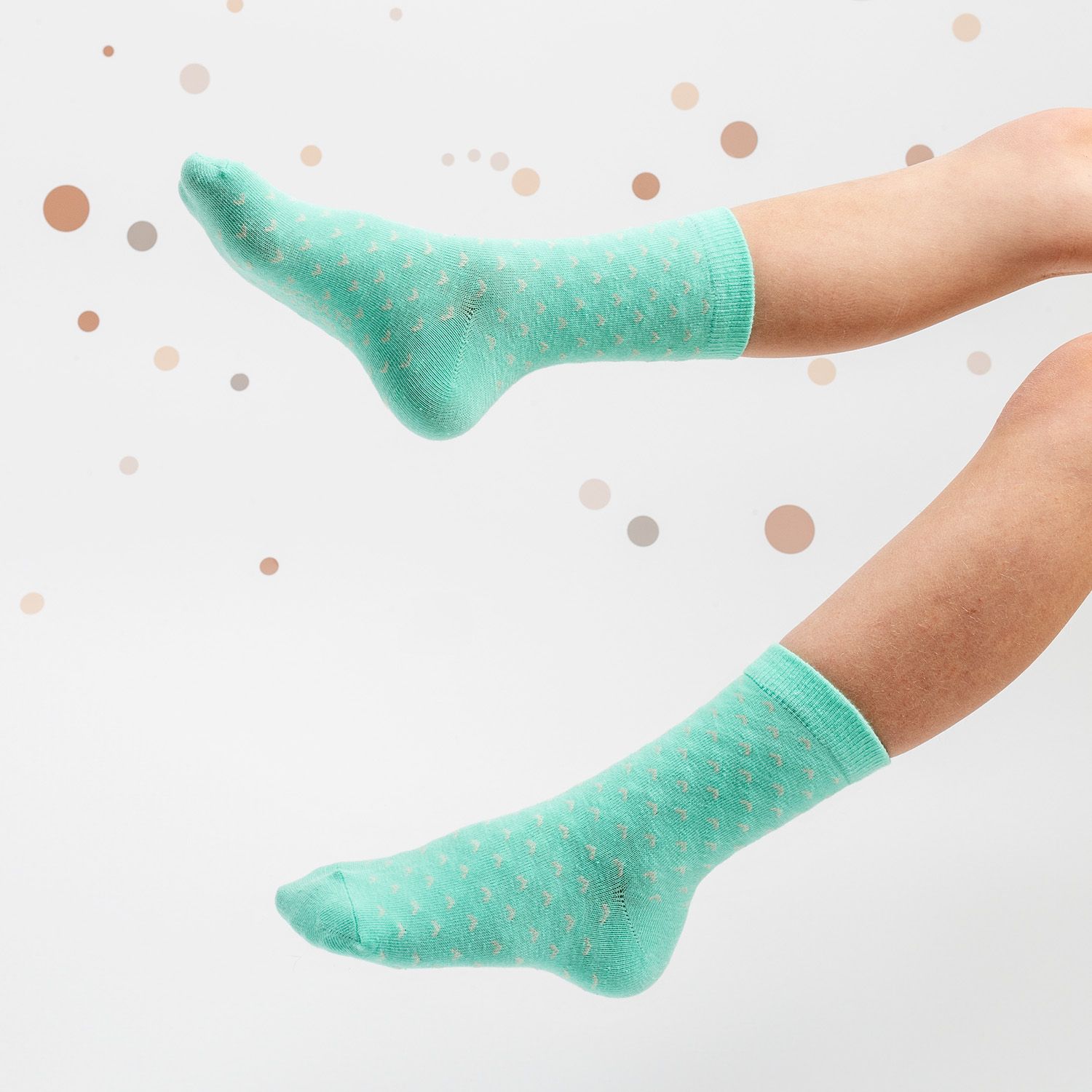 Türkisfarbene Socken mit weißen Sternen. Kind trägt die Socken. Hintergrund: weiß mit Punkten.
