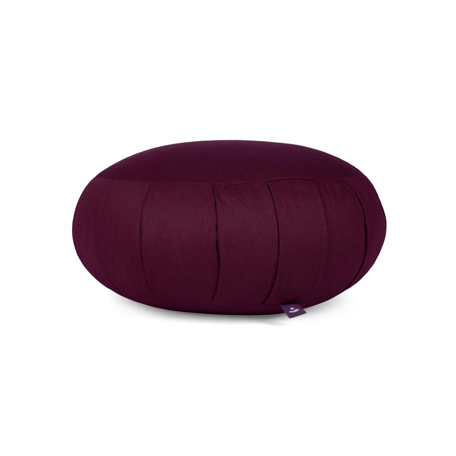Bordeauxfarbenes Meditationskissen ZAFU. Rund, mit Falten und kleinem Label. Auf hellem Hintergrund.