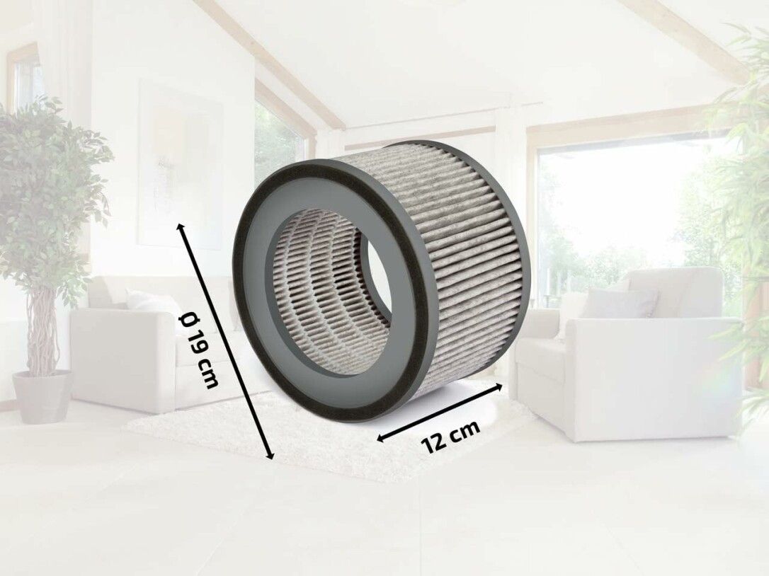 Zylindrischer Filter, grau, mit schwarzem Rand. Durchmesser 19 cm, Höhe 12 cm. Im Wohnzimmer platziert.