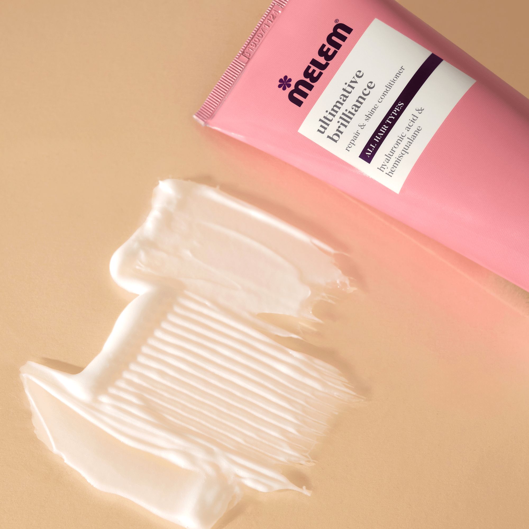 Rosa Tube, Produkt auf Oberfläche. Aufschrift: Melem, ultimative Brilliance, Repair & Shine Conditioner. Für alle Haartypen.