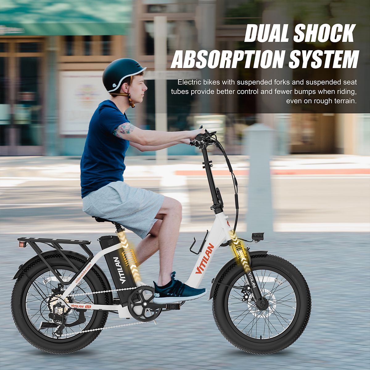 E-Bike mit Dual-Stoßdämpfung. Fahrer auf dem Fahrrad. Gelb-weißes Fahrrad mit Gepäckträger. VITILAN-Logo.