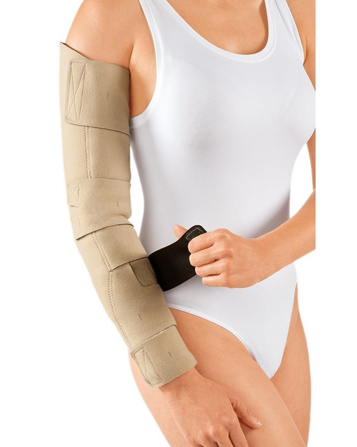 Armkompressionssystem. Beige, mit Klettverschlüssen. Am Arm einer Person getragen. Schwarzer Verschluss.