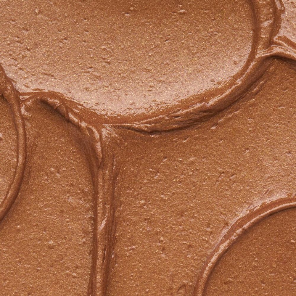Nahaufnahme einer braunen Bronzer-Textur. Die Textur ist cremig und schimmernd.